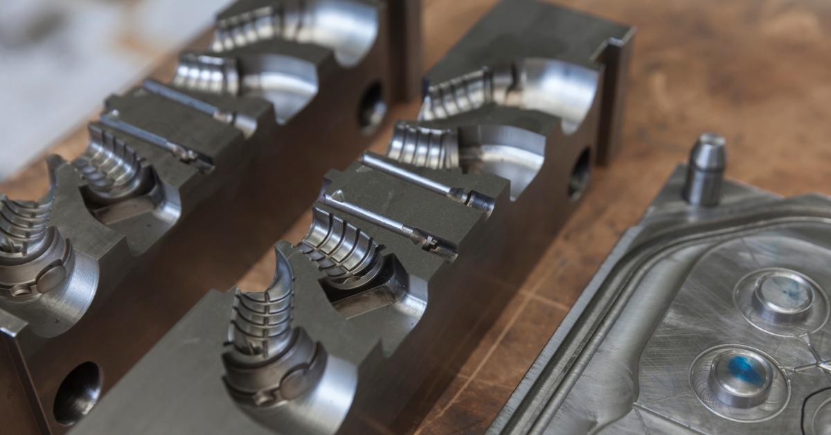 A close-up view shows two metal mold trays that are ready for use. The molds are rectangular and dark-gray.