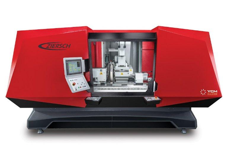 A large red and black industrial machine has a window in the middle showing the intricate details inside.